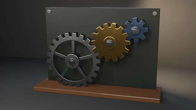 A brass fourteen-tooth gear meshing with a blued pinion and a spoked gunmetal wheel, each bolted through a hub to a dark steel backplate on a walnut plinth.