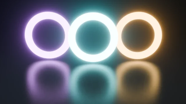 Three glowing neon rings, violet, cyan and warm white, with fog-glow bloom and reflections on the floor.